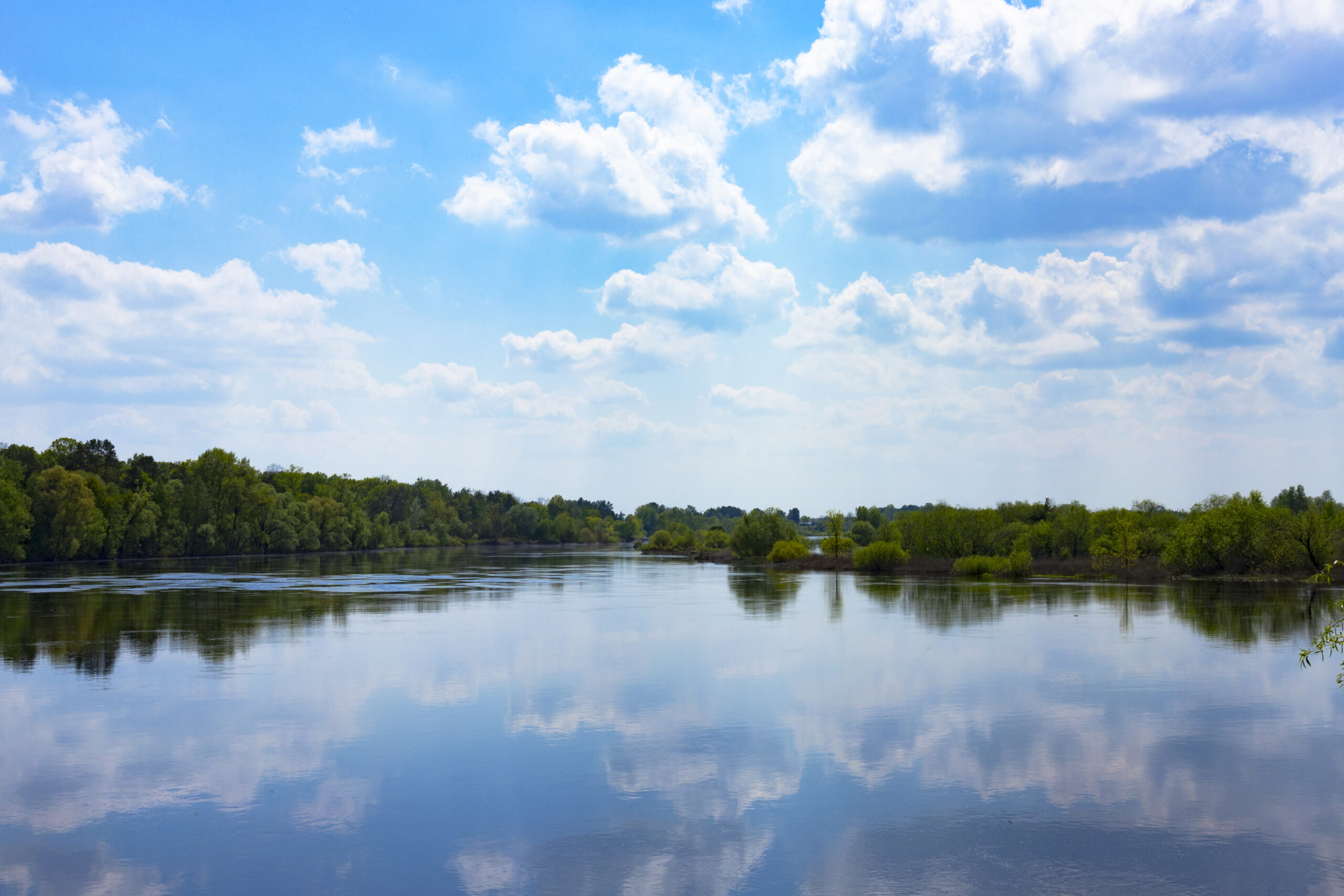 Wide river with green coasts and sky with clouds Wide river with green coasts and sky with clouds